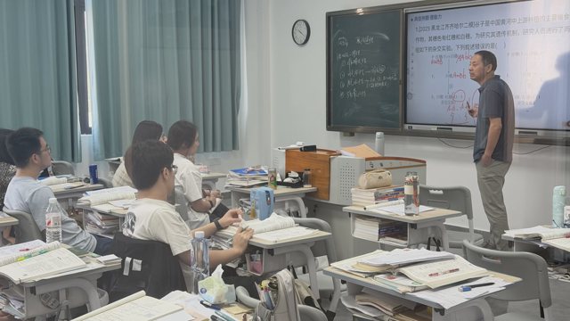 武汉襄五学校课堂实拍:教师在教室前方讲解,屏幕呈现遗传相关图示