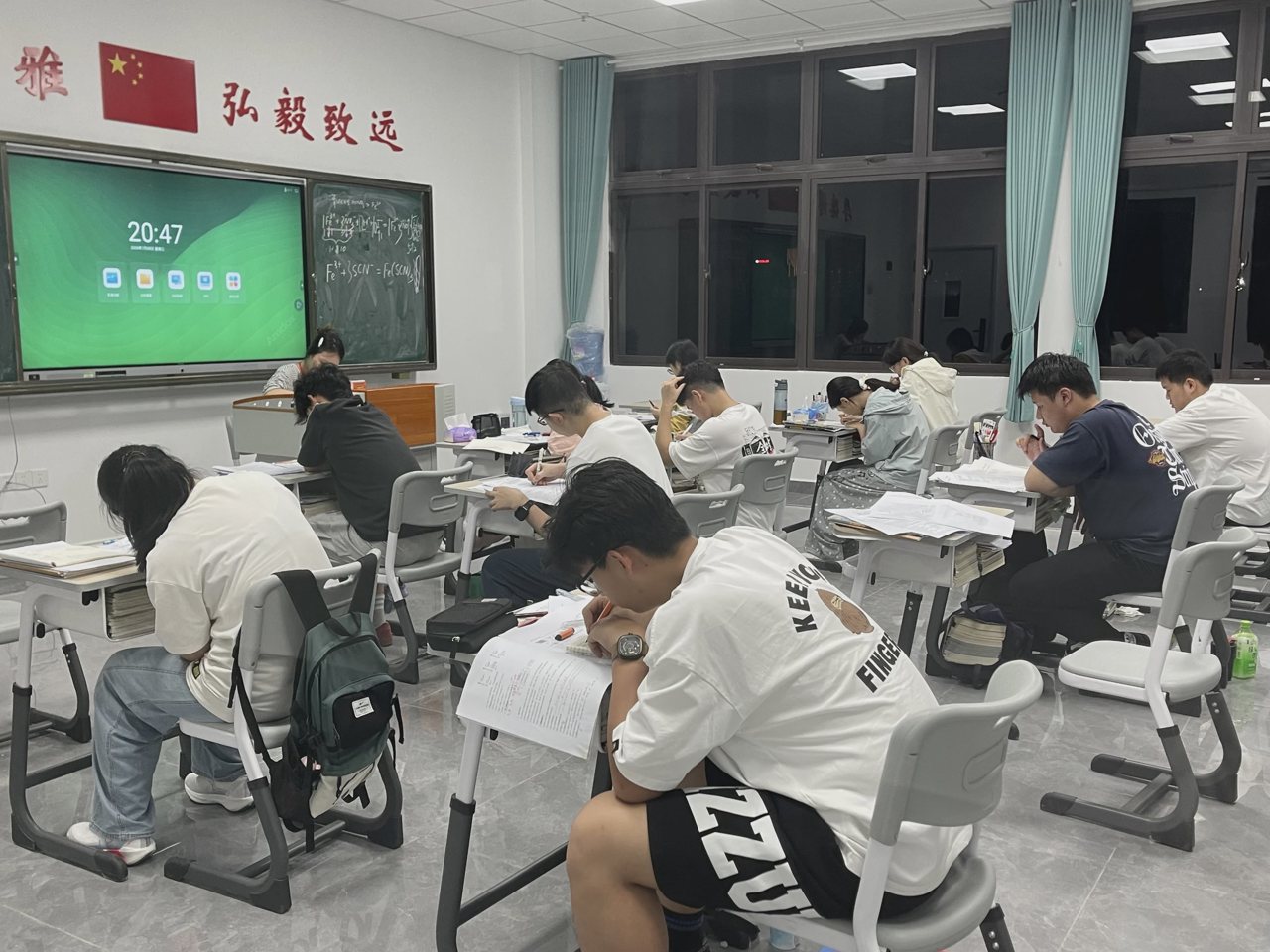 武汉襄五学校教室实拍:学生在课桌前阅读书写,窗外光线较暗